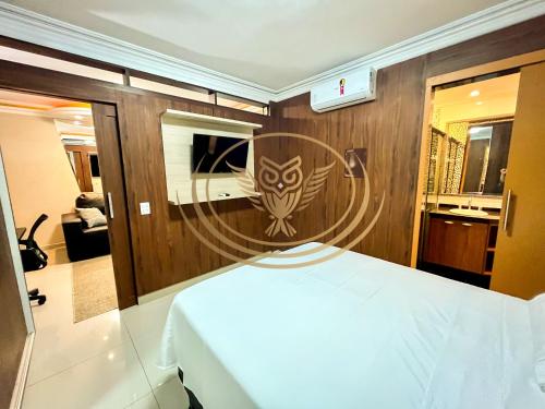 a bedroom with a wooden wall with an owl decal on it at Coruja Imob - Flat Crystal Place in Goiânia