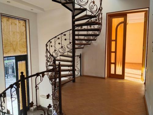a spiral staircase in a room with a door at Villa Vanila in Kutaisi