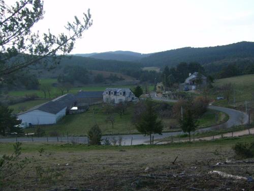 a house on a hill with a road in the distance at Chez Louis chambres d'hôtes à la ferme in La Canourgue
