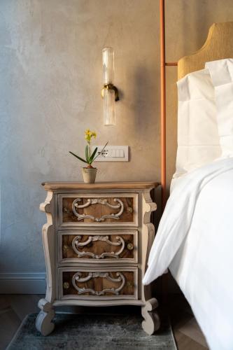 a bedroom with a bed and a dresser with a plant on it at Palazzo Doni by Florence Art Apartments in Florence