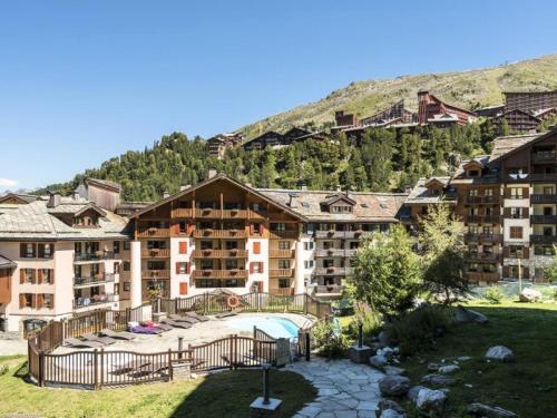 un grand immeuble en face d'une montagne dans l'établissement Résidence Les Arcs 1950 Le Village - maeva Home - Appartement 4 pièces 8 personnes - Exclusive MAE-4121, à Arc 1950