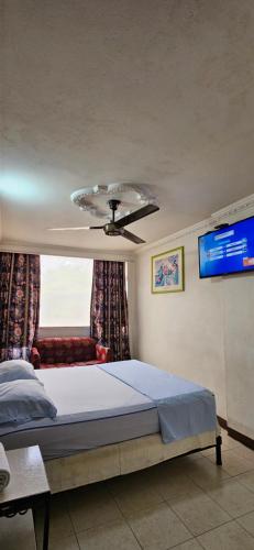 Un dormitorio con una cama y un ventilador de techo. en Hotel Terraza Girardot, en Girardot