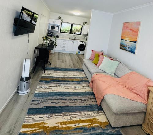 a living room with a couch and a rug at Waterfront studio unit near Auckland Airport in Auckland