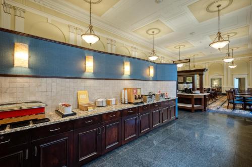 a kitchen with wooden cabinets and a blue wall at Hampton Inn & Suites Providence Downtown in Providence