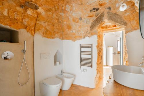 a bathroom with a tub and a toilet and a sink at Trullo dei Beneficati By Vivimy in Taviano