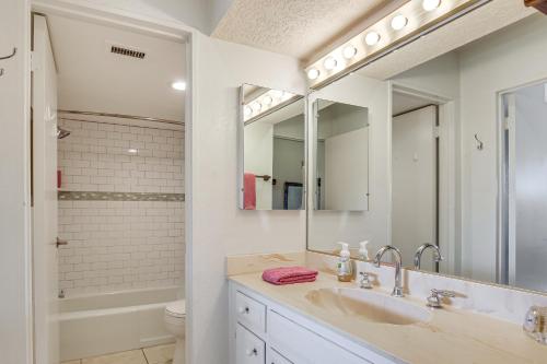 a white bathroom with a sink and a tub at 3 Mi to Dtwn Palm Springs Condo with Pool Access! in Palm Springs