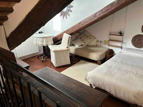 ヴェネツィアにあるIndipendent house in Veniceのベッドと椅子付きの屋根裏部屋