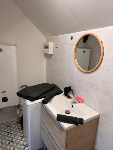 een badkamer met een wastafel en een spiegel bij La Planque des Halles - Hyper Centre - Bureau in Troyes