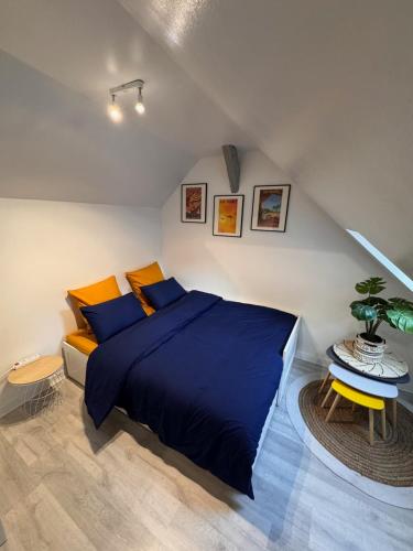 een slaapkamer met een groot blauw bed en een tafel bij La Planque des Halles - Hyper Centre - Bureau in Troyes
