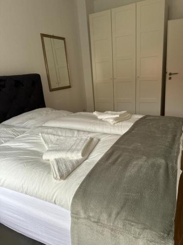 a bed with white sheets and towels on it at Altstadtinsel am Johanneum in Lübeck