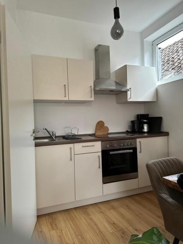 a kitchen with white cabinets and a stove top oven at Altstadtinsel am Johanneum in Lübeck