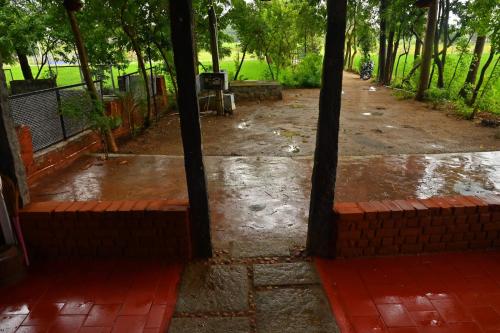 a view of a dirt road with trees and a motorcycle at Pathayam Inn in Tiruvannāmalai