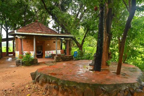 a small pavilion in a park with a tree at Pathayam Inn in Tiruvannāmalai