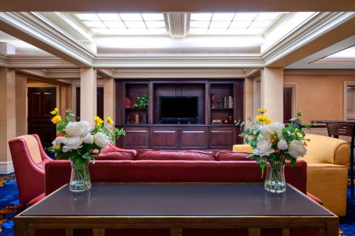 a living room with a red couch and flowers on a table at Hampton Inn & Suites Providence Downtown in Providence