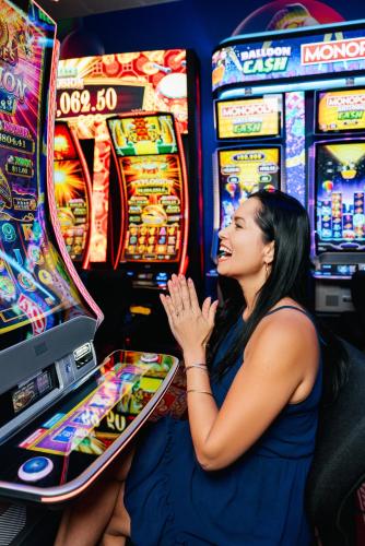 a woman sitting at a slot machine in a casino at Virgin River Casino and Lodge in Mesquite