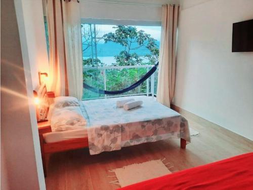 En eller flere senge i et værelse på Yumi Chalés Ilhabela