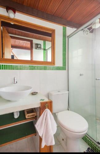 a bathroom with a toilet and a sink and a mirror at Buzios Casa #6 in Búzios