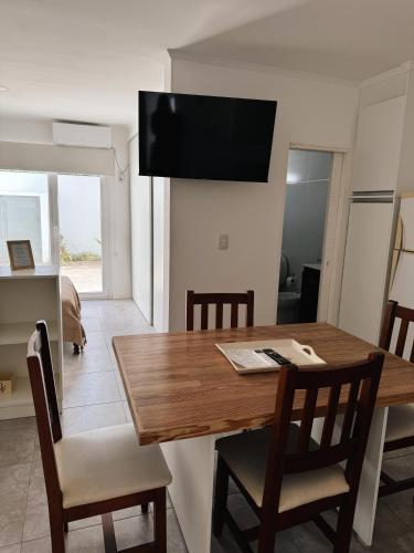 a dining room with a wooden table and chairs at Departamento Balcarce en Olavarría in Olavarría