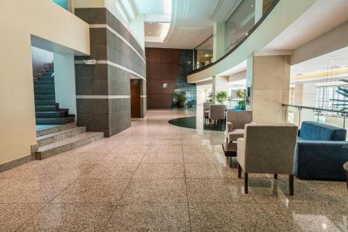 a lobby with chairs and stairs in a building at Sheraton Guayaquil in Guayaquil