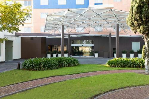 a building with a metal canopy in a park at Courtyard Toluca Tollocan in Toluca