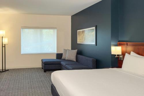 a hotel room with a bed and a chair at Courtyard Toluca Tollocan in Toluca