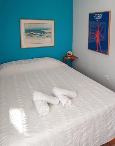 a white bed with two towels on top of it at Sophia houses by the sea in Nea Kalikratia