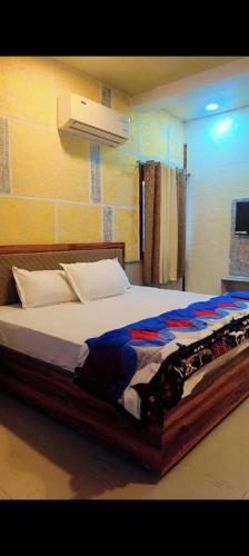 a bedroom with a large bed with avertisement at Unnati Guest House in Vrindāvan