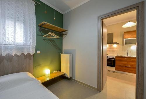 a small bedroom with a bed and a kitchen at Sophia houses by the sea in Nea Kalikratia