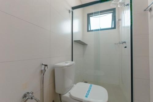 a white bathroom with a shower and a toilet at Estiloso, Central e Lindo in Maringá