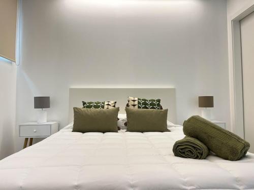 a large white bed in a white bedroom at Quinta das Pedreiras Lux in Pico da Pedra