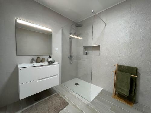 a white bathroom with a shower and a sink at Quinta das Pedreiras Lux in Pico da Pedra
