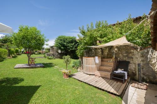 a garden with a wooden deck with a hot tub at Apartment House Artes with Free Hot Tub & Sauna in Branik