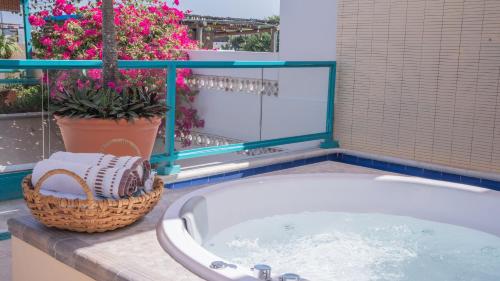 a bath tub in a bathroom with flowers at Posada La Fe in Cartagena de Indias