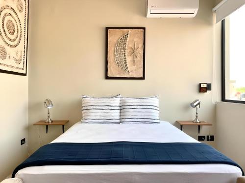 a bedroom with a blue and white bed with two lamps at Mangle By Andiani in Cancún