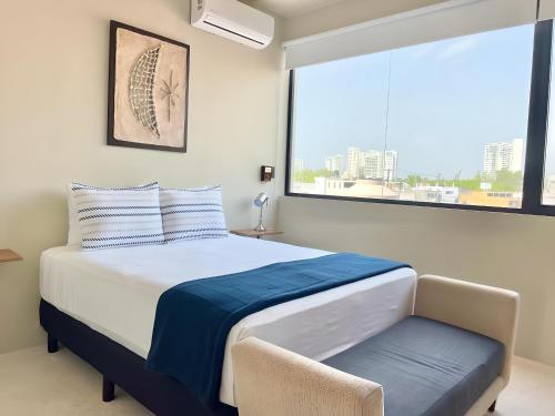 a bedroom with a bed and a large window at Mangle By Andiani in Cancún