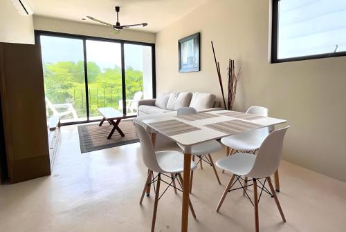 a dining room with a white table and chairs at Mangle By Andiani in Cancún