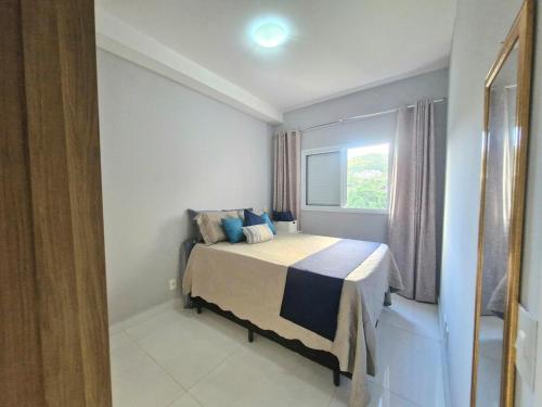 un dormitorio con una cama y una ventana en Charmoso com varanda - Ar condicionado - 1 Vaga, en Santos