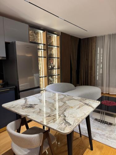 a dining room with a marble table and chairs at Stayinn Emerald Shkoder in Shkodër