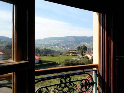 a window with a view of a green field at Selgas de Cudillero in Cudillero