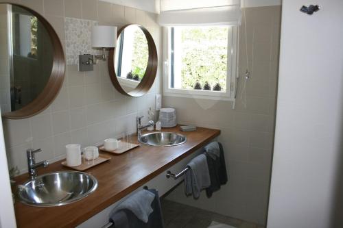 une salle de bain avec deux lavabos et deux miroirs dans l'établissement A Loctudy Splendide villa à 300 mètres de la plage, à Loctudy