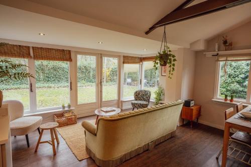 a living room with a couch and windows at Boshuisje op de Veluwe in Nunspeet