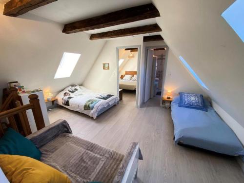 a attic room with two beds and a couch at Gîte de France à Darazac 2 épis - Gîte de France 2 personnes MAE-5181 in Darazac