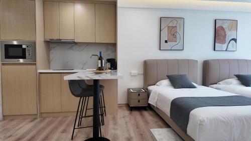 a hotel room with two beds and a small kitchen at CC LUX Suites in Piraeus