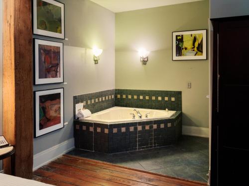 a bathroom with a tub and paintings on the wall at Lancaster Arts Hotel in Lancaster