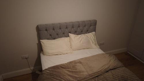 a bed with a headboard with white pillows at UNESCO Drogheda 3 Bed in Drogheda