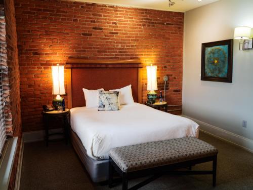 a bedroom with a bed and a brick wall at Lancaster Arts Hotel in Lancaster
