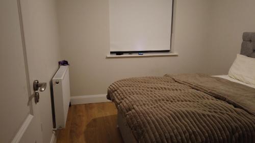 a small bedroom with a bed and a window at UNESCO Drogheda 3 Bed in Drogheda
