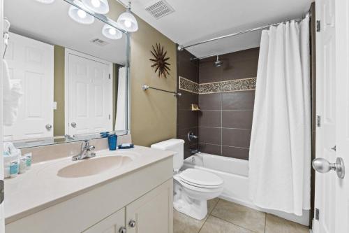 a bathroom with a sink and a toilet and a mirror at Summerlin 502 in Fort Walton Beach