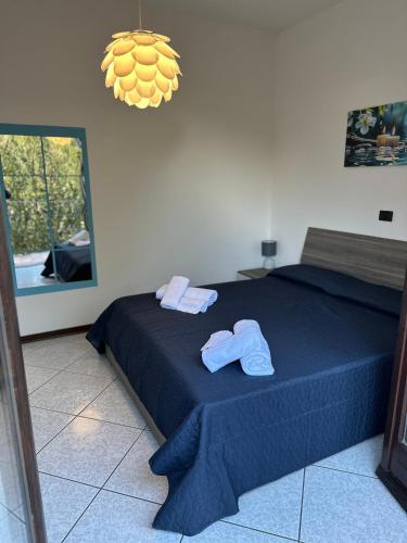 a bedroom with a blue bed with towels on it at Casa Ohana in Gravellona Toce
