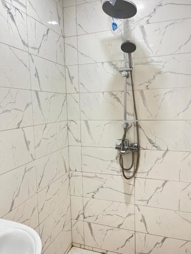 a bathroom with a shower with white marble walls at Centre D'estivage Imi Ouaddar in Agadir nʼ Aït Sa